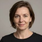 Профессиональный портрет уверенного российского бизнесмена с дружелюбным взглядом на размытом нейтральном фоне